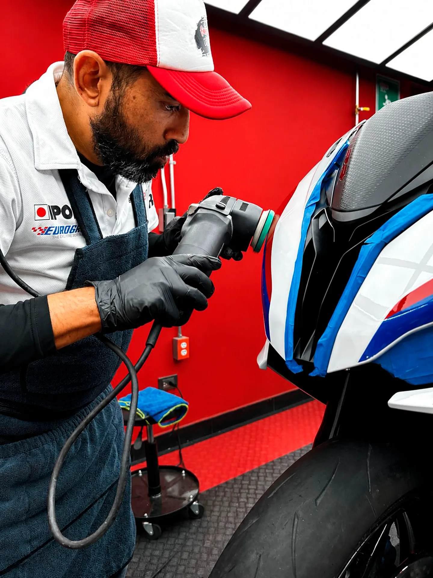 Operador de El FKing Rider puliendo la superficie de una motocicleta BMW